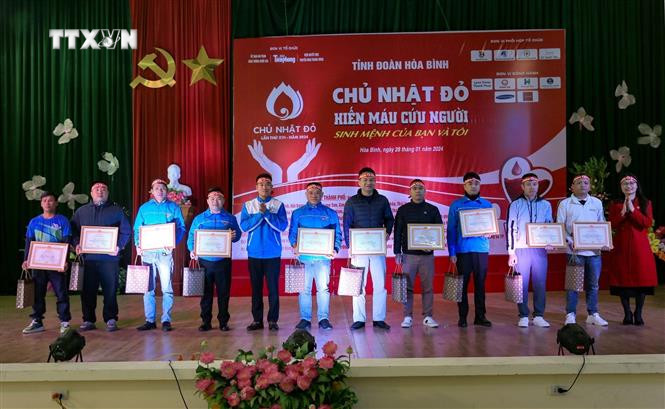 Ban tổ chức tuyên dương các tình nguyện viên tiêu biểu. Ảnh: Trọng Đạt-TTXVN vna_potal_chuong_trinh_“chu_nhat_do”_va_ngay_hoi_“xuan_hoa_binh”_lan_thu_viii_nam_2024_7202145.jpg