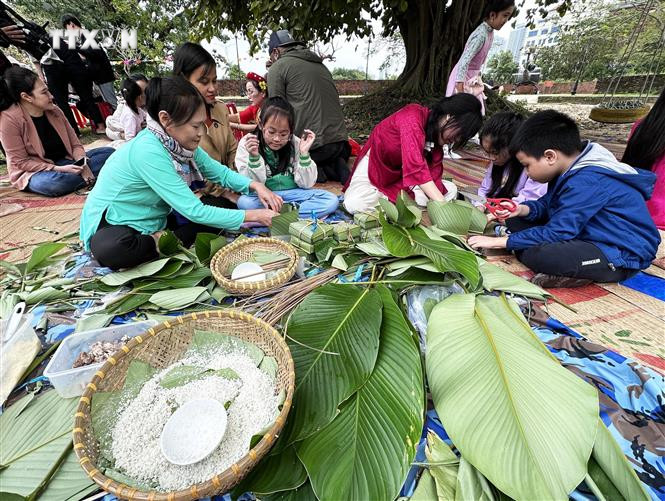 Khách tham gia trải nghiệm gói bánh chưng tại Phiên chợ ngày Tết 2024 ở Đà Nẵng. Ảnh: Trần Lê Lâm - TTXVN vna_potal_da_nang_to_chuc_phien_cho_ngay_tet_2024__7201223.jpg