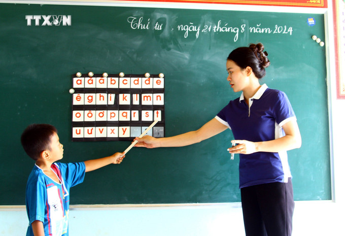Giáo viên dạy tăng cường tiếng Việt cho học sinh dân tộc thiểu số tại điểm trường lẻ thuộc Trường Tiểu học và THCS xã Thượng Hóa, huyện Minh Hóa. Ảnh: Tá Chuyên – TTXVN vna_potal_quang_binh_cac_truong_hoc_huyen_mien_nui_minh_hoa_chuan_bi_don_nam_hoc_moi_7555558.jpg