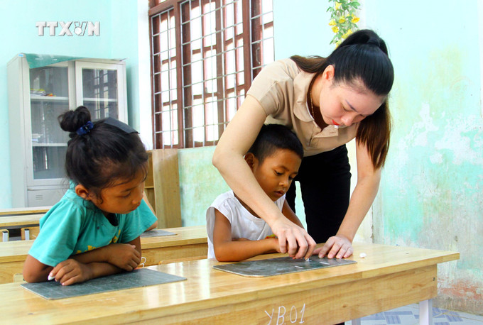 Giáo viên dạy tăng cường tiếng Việt cho học sinh dân tộc thiểu số tại Trường Tiểu học và THCS xã Thượng Hóa, huyện Minh Hóa. Ảnh: Tá Chuyên – TTXVN vna_potal_cac_truong_hoc_huyen_mien_nui_minh_hoa_quang_binh_san_sang_don_nam_hoc_moi_7555555.jpg