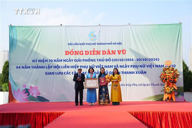Công bố quyết định xác lập Kỷ lục Việt Nam cho Hội Liên hiệp phụ nữ thành phố Hà Nội về “Chương trình đồng diễn dân vũ với áo dài tại các xã, phường, thị trấn trên địa bàn thành phố Hà Nội có số lượng phụ nữ tham gia biểu diễn nhiều nhất Việt Nam”. Ảnh: Nguyễn Cúc-TTXVN vna_potal_70_nam_giai_phong_thu_do_hon_70000_phu_nu_thu_do_dong_dien_dan_vu_voi_ao_dai_7661036.jpg