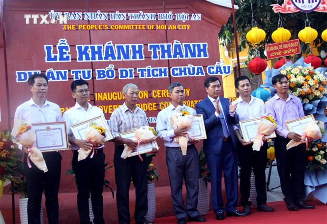 Ông Nguyễn Văn Sơn - Chủ tịch Ủy ban nhân dân thành phố Hội An khen thưởng cho các tập thể, cá nhân có thành tích xuất sắc trong trùng tu Chùa Cầu. Ảnh: Trịnh Bang Nhiệm - TTXVN vna_potal_thanh_pho_hoi_an_to_chuc_khanh_thanh_du_an_tu_bo_di_tich_chua_cau___7519865.jpg