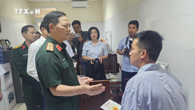 Trung tướng Phạm Trường Sơn thăm hỏi, động viên thượng tá Nguyễn Hồng Quân (Chủ nhiệm bay). Ảnh: Sỹ Thắng-TTXVN vna_potal_tham_hoi_2_phi_cong_trong_vu_may_bay_quan_su_roi_o_binh_dinh_7691471.jpg