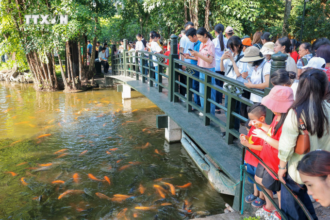Người dân thăm ao cá Bác Hồ trong Khu di tích Chủ tịch Hồ Chí Minh. Ảnh: Hoàng Hiếu - TTXVN vna_potal_hang_van_nguoi_vao_lang_vieng_chu_tich_ho_chi_minh_dip_79_nam_quoc_khanh_7569311.jpg