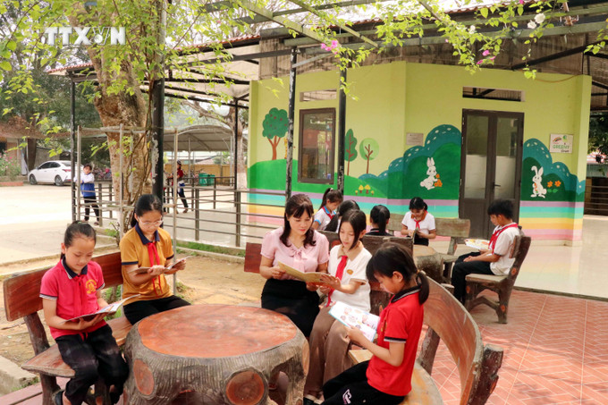 Học sinh đọc sách tại khu vực đọc ngoài trời của Thư viện Cầu vồng, Trưởng Tiểu học Tứ Quận, huyện Yên Sơn. Ảnh: Quang Cường – TTXVN vna_potal_tuyen_quang_lan_toa_van_hoa_doc_trong_nha_truong_7326461.jpg