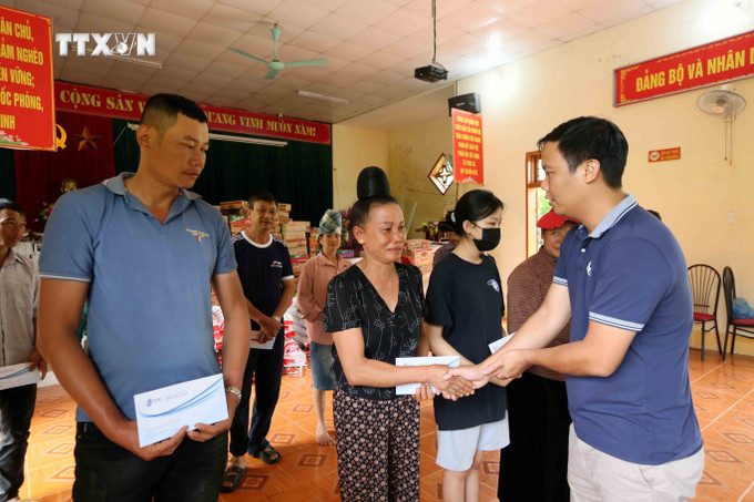 Các nhà hảo tâm trao tiền hỗ trợ cho nhân dân xã Tông Cọ, huyện Thuận Châu, tỉnh Sơn La. Ảnh: Quang Quyết - TTXVN vna_potal_son_la_ho_tro_nhan_dan_vung_ngap_lut_xa_tong_co_vuot_qua_kho_khan__7511742.jpg