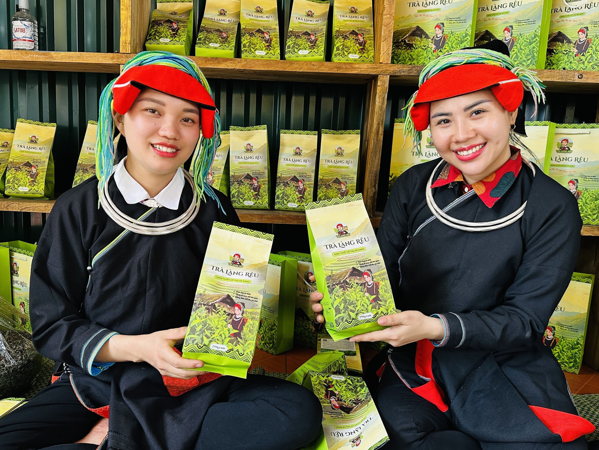 Cô gái người Dao Bàn Thị Hom (bên trái) giới thiệu sản phẩm chè tự tay mình làm nên Cô gái người Dao Bàn Thị Hom (bên trái) giới thiệu sản phẩm chè tự tay mình làm nên