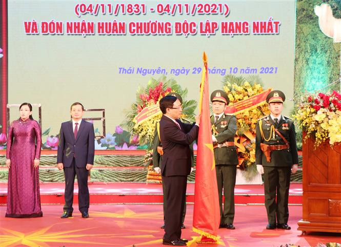 Phó Thủ tướng Thường trực Chính phủ Phạm Bình Minh thực hiện nghi thức trao tặng Huân chương Độc lập hạng Nhất cho Đảng bộ và nhân dân tỉnh Thái Nguyên. Ảnh: Hoàng Nguyên - TTXVN