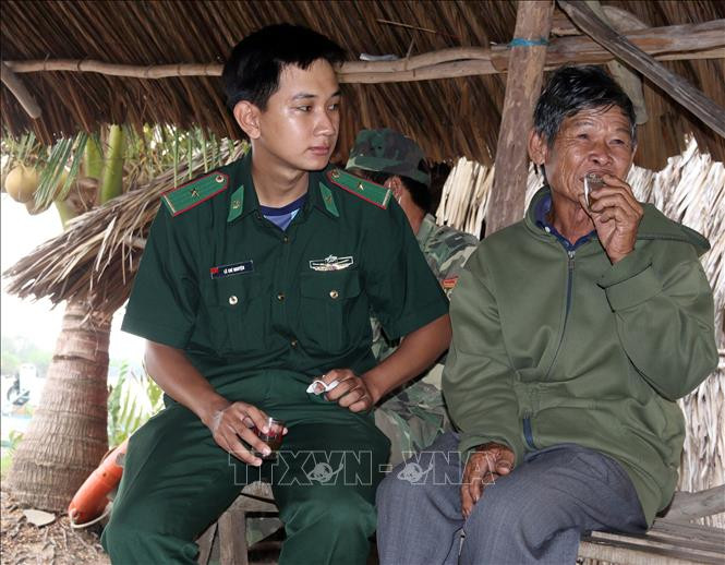 Cán bộ, chiến sỹ Đồn Biên phòng Phú Mỹ đến thăm, động viên ông Lý Văn Nhợi, ngụ ấp Trà Phô, xã Phú Mỹ. Ảnh: Lê Sen – TTXVN