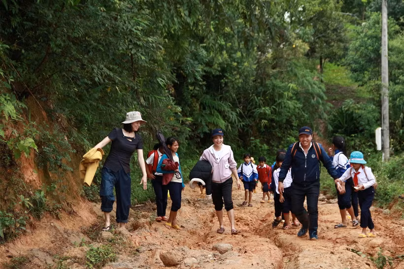 Cô Hồ Thị Thùy Vân (ngoài cùng bên trái) cùng đồng nghiệp vận động đưa học sinh đến lớp. Ảnh: baotintuc.vn