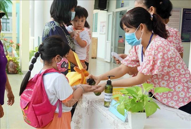 Giáo viên Trường Mầm non Tuổi thơ (Quận 8) hướng dẫn trẻ rửa tay trước khi vào lớp. Ảnh: Thu Hoài - TTXVN