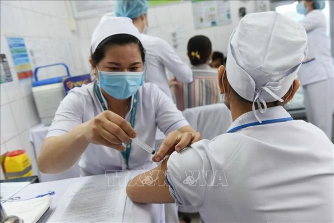 Những nhân viên y tế đầu tiên được tiêm vaccine phòng COVID-19. Ảnh: Đinh Hằng - TTXVN