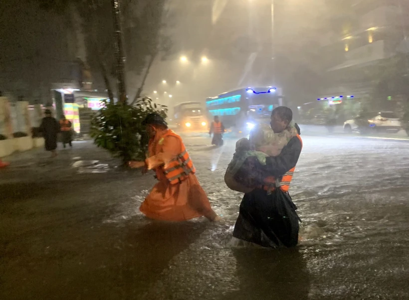Lực lượng chức năng phường Hòa Khánh Nam (quận Liên Chiểu, Đà Nẵng) khẩn trương đưa trẻ em tại các hộ dân bị ngập đến nơi an toàn. Ảnh: TTXVN phát