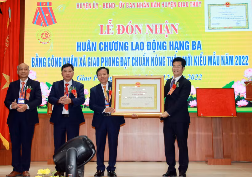 Phó Chủ tịch Thường trực UBND tỉnh Nam Định Trần Anh Dũng trao Bằng công nhận xã đạt chuẩn nông thôn mới kiểu mẫu giai đoạn 2021-2025 cho lãnh đạo xã Giao Phong. Ảnh: Văn Đạt - TTXVN