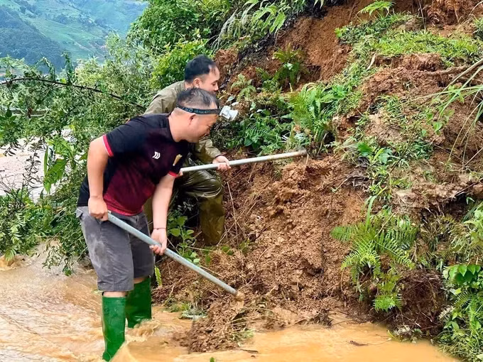 Lực lượng Công an xã Mù Cang Chải xử lý điểm sạt lở, mở lối đi cho người dân. Ảnh: TTXVN phát