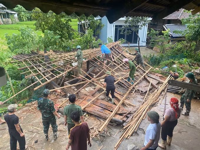 Chính quyền địa phương và các lực lượng chức năng hỗ trợ người dân Dương Quỳ khắc phục hậu quả thiên tai. Ảnh: TTXVN phát