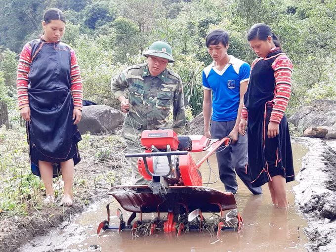 Cán bộ, chiến sỹ Bộ đội Biên phòng Lai Châu hướng dẫn bà con nhân sử dụng máy cày làm đất để trồng lúa nước. Ảnh: Công Tuyên/TTXVN