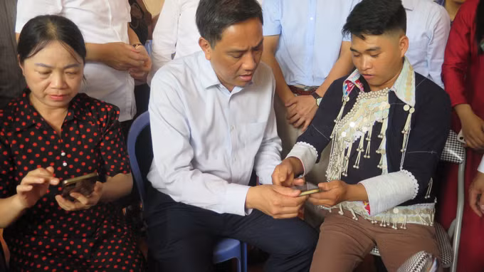 Lãnh đạo tỉnh Lào Cai và người dân xã Bát Xát trải nghiệm các tiện ích "Thôn số" trên thiết bị di động thông minh.