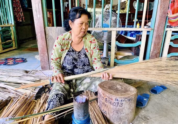 Người dân ấp Đông An, xã Phú Hòa, tỉnh An Giang tận dụng sân nhà, mái hiên để làm chổi cọng dừa.