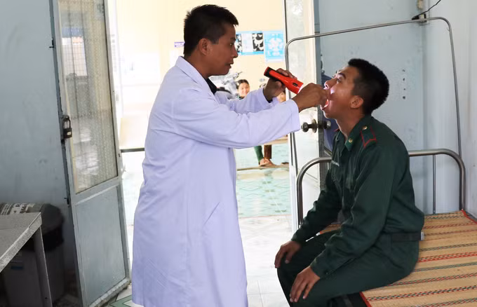 Nhân viên phòng khám đang khám bệnh cho chiến sĩ Trạm Kiểm soát Biên phòng cửa khẩu quốc tế Dinh Bà, Đồn Biên phòng cửa khẩu quốc tế Dinh Bà, Bộ đội Biên phòng tỉnh Đồng Tháp.